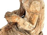 a statue of a woman sitting on a rock with her hand on her chin