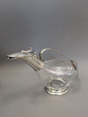 théière en verre plaqué argent avec une anse et une poignée