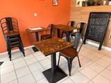 des tables et des chaises dans une pièce aux murs orange, avec un tableau noir