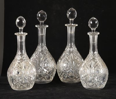 trois carafes en verre transparent avec des bouchons en cristal, sur fond noir