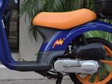 a blue and orange scooter parked in front of a building