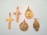 quatre croix en or, une croix et une médaille sur un fond blanc