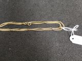 a close up of a gold chain with a tag attached to it