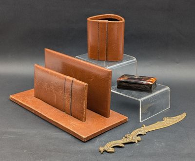 a brown leather desk set with a knife, wallet, and case
