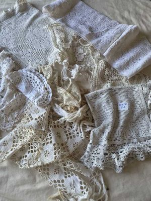 une pile de vêtements au crochet posée sur un lit