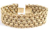 gros plan d'un bracelet en or sur fond blanc
