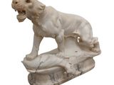 marble statue of a lion on a rock with its mouth open