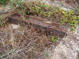 a rusted piece of metal sitting in the middle of a field