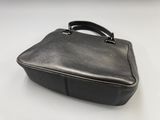 black leather briefcase on a white table with a white background