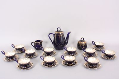 many cups and saucers and a teapot on the table