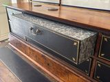 a picture of a dresser with drawers and a painting on the wall