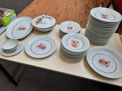 une table sur laquelle se trouvent beaucoup d'assiettes et de bols