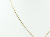 a gold necklace with a diamond on a mannequin neck