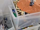 two plastic bins with legos in them on the floor