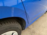 a close up of a blue car parked in a parking lot