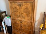 a wooden armoire with a clock on top of it