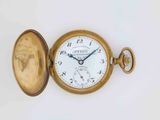 a gold pocket watch with a white face on a white surface