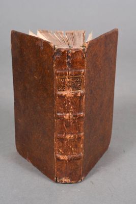 un vieux livre à la couverture brune posé sur une table