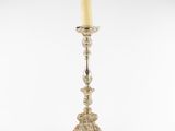 a silver candle holder with a candle on top of it