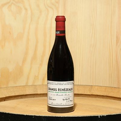 a bottle of wine sitting on top of a barrel