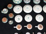 many cups and saucers with numbers on them on a table