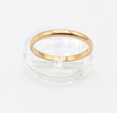 une image représentant une bague transparente et dorée posée sur une surface blanche