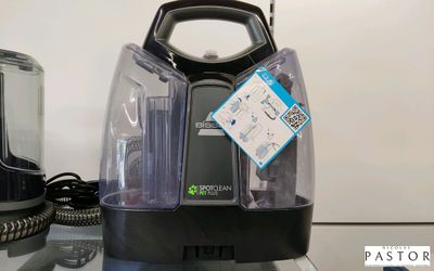 un aspirateur noir et argenté posé sur une table en verre
