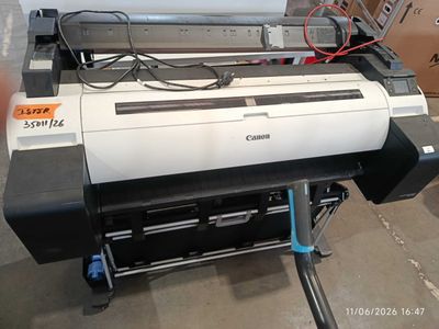 a large printer sitting on top of a cart in a warehouse