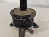 a small black object on a stand on a white surface