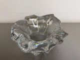 a glass bowl on a table with a white wall in the background