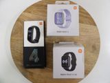 trois montres différentes posées sur un plateau en bois posé sur une table