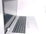 a silver laptop with a black keyboard on a white surface