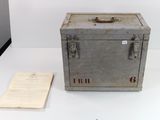 an old metal box with a piece of paper next to it