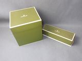 pair of green boxes with white trims on a grey background