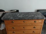 une commode avec un plateau en marbre, placée dans un coin de la pièce