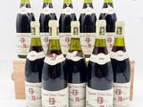 six bouteilles de vin sont alignées dans une caisse en bois