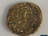 a close up of a gold coin with a bird on it