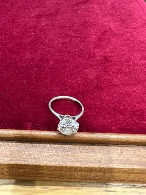 une bague en diamant posée sur un coussin en velours rouge