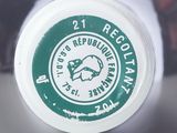 a close up of a bottle with a green cap on it