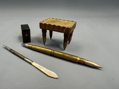 un stylo, un couteau et une boîte posés sur une table
