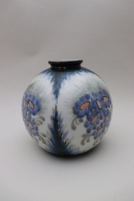 un vase bleu et blanc posé sur une surface blanche