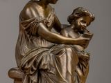 bronze statue of a woman and child sitting on a bench