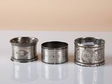 three silver napkins sitting on top of a table next to each other