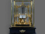 une horloge posée sur une table, à l'intérieur d'une vitrine