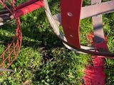 a red metal object that is sitting in the grass