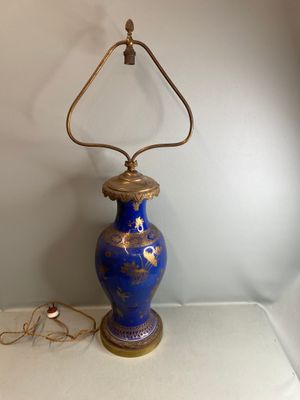 un vase bleu orné d'un motif doré, posé sur une table