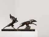 statue of a man on a horse chasing a dog on a pedestal