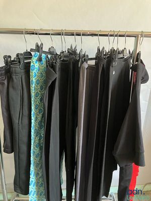 beaucoup de vêtements suspendus à une étagère dans une pièce