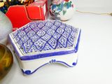 a small blue and white box sitting on a table next to other items