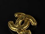 a chanel gold brooch with a circular design on it